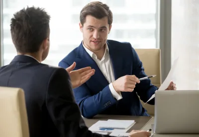 Successful businessman clarifying provisions of contract with business partner, discussing terms of agreement, explaining strategy or financial plan. HR manager asking job candidate about his resume
